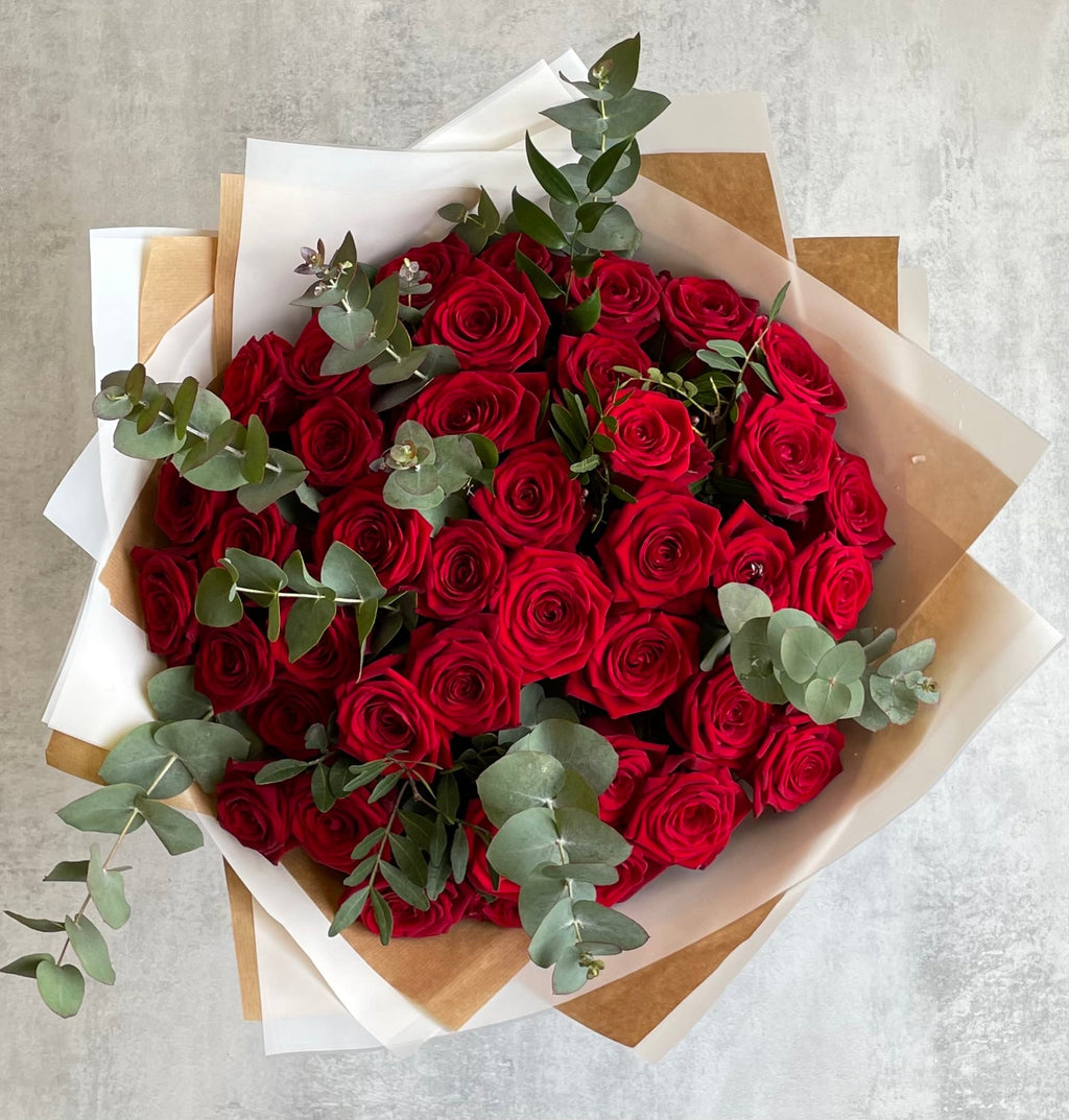 Premium red roses arranged in a hand-tied bouquet